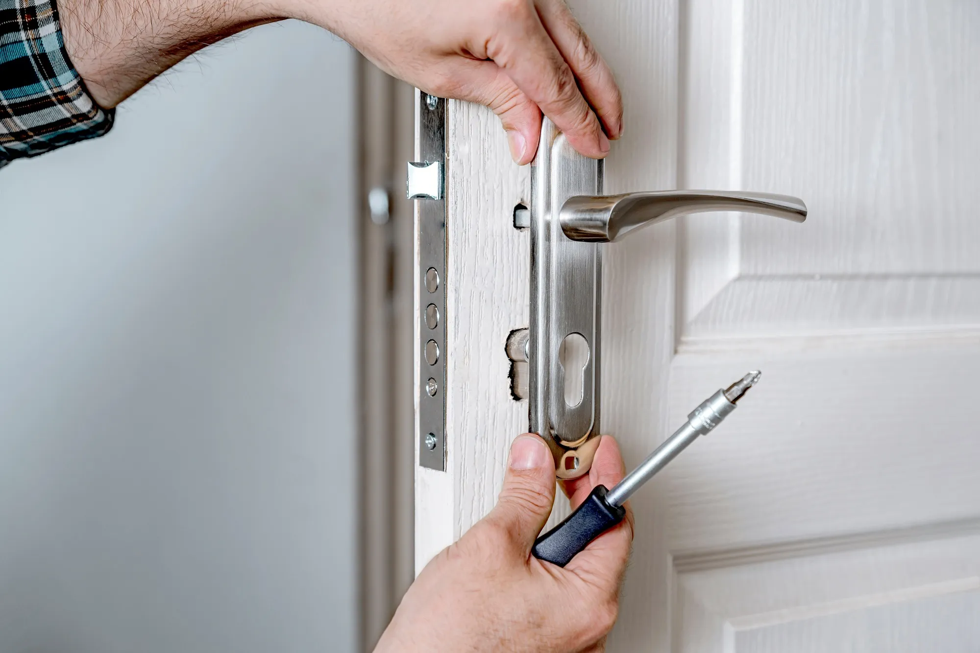 A person opening a door with a key in their hand.