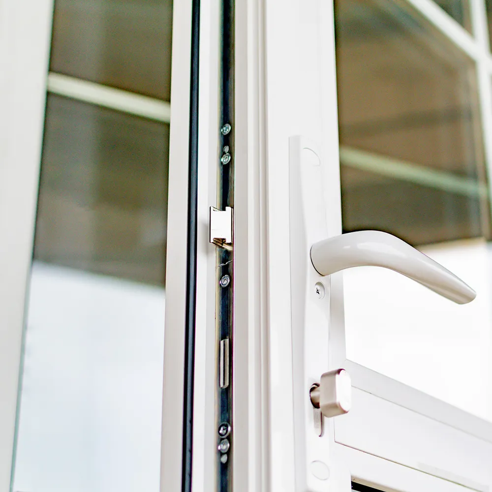 A close up of a door handle on a white door.
